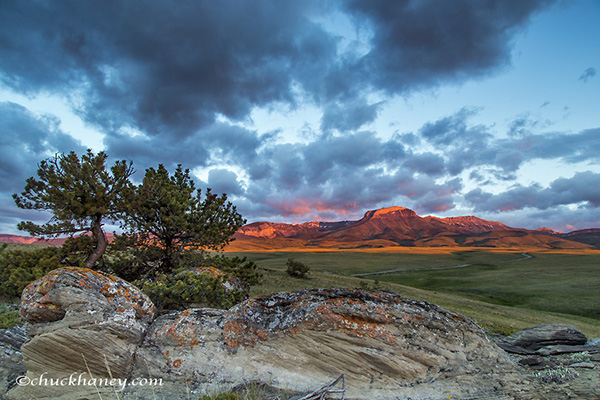Fiery sunrise light strikes Ear Mountain along the Rocky Mountain Front near Choteau, Montana, USA