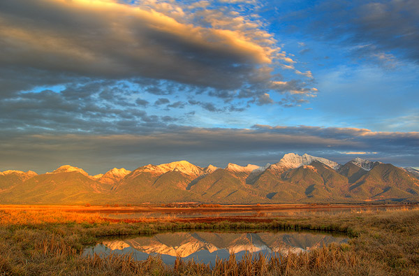 Pond at the Ninepipe NWR reflects dramatic light of the Mission Mountains in Montana